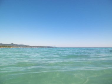 Mavi, şeffaf Tyrhenian deniz suyu mavi gökyüzü arka planında. Tatiller ve doğa konsepti. Boşluğu kopyala.