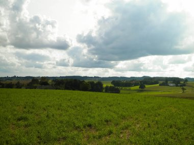 Rainy day over green fields and meadows of Kashubian Region, Poland. Copy space on cloudy sky.