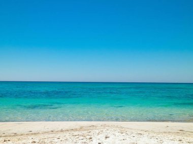 Vada 'daki kumsal, şeffaf, turkuaz su ve beyaz kum. Seyahat ve doğa kavramı.