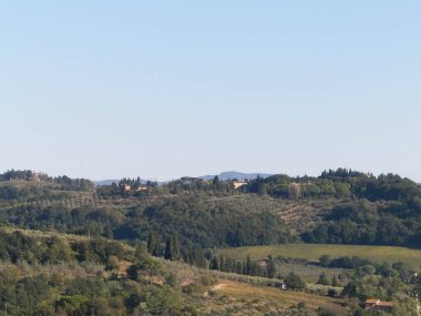 Tepeler, tarlalar ve çayırlar - tipik Toskana manzarası, İtalya. Seyahat, doğa ve tarım kavramı. Güneşli bir sonbahar günü, İtalya 'da tatiller. Boşluğu kopyala.