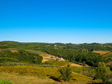 Tepeler, tarlalar ve çayırlar - tipik Toskana manzarası, İtalya. Seyahat, doğa ve tarım kavramı. Güneşli bir sonbahar günü, İtalya 'da tatiller. Boşluğu kopyala.