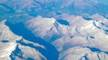 Alpler, uçağın penceresinden dağların manzarası. Toprak bükme ve doğa kavramı.