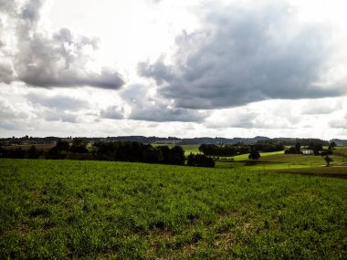 Rainy day over green fields and meadows of Kashubian Region, Poland. Copy space on cloudy sky.