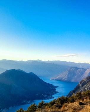 Sunny day over Lovocen Mountain tops and Kotor Bay fjords. The Lovcen Mountains lie around Boka Kotorska in Montenegro. Kotorska bay in a foreground. clipart