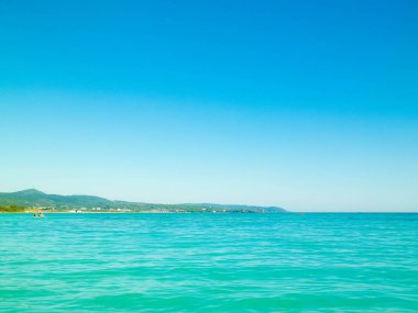 Sahil ve şeffaf, Tiren Denizi 'nin turkuaz suyu. Seyahat ve doğa kavramı. Güneşli bir yaz günü. Boşluğu kopyala.