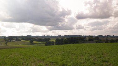 Rainy day over green fields and meadows of Kashubian Region, Poland. Copy space on cloudy sky.