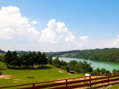 Polonya, Kashubia 'daki Wiezyca bölgesinin kırsal arazisi. Arka planda otlaklar, çayırlar ve Ostrzyckie gölü.