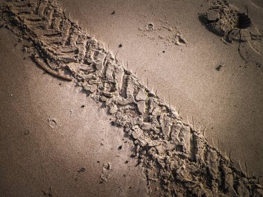 Çölün veya kumsalın üzerindeki lastik izleri. Doğal arka plan. Offroad ve seyahat kavramı.