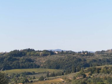 Tepeler, tarlalar ve çayırlar - tipik Toskana manzarası, İtalya. Seyahat, doğa ve tarım kavramı. Güneşli bir sonbahar günü, İtalya 'da tatiller. Boşluğu kopyala.