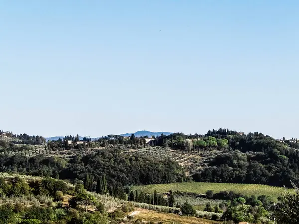 Tepeler, tarlalar ve çayırlar - tipik Toskana manzarası, İtalya. Seyahat, doğa ve tarım kavramı. Güneşli bir sonbahar günü, İtalya 'da tatiller. Boşluğu kopyala.