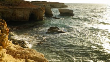 Kıbrıs adasının Paphos bölgesindeki Mercan Koyu 'na yakın kaya oluşumları ve su mağaraları. Popüler bir turistik site. Yaz mevsimi.