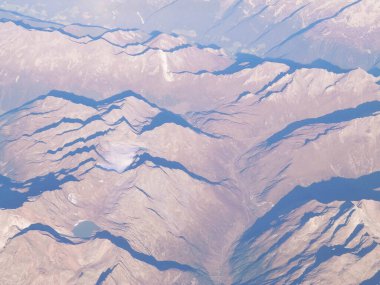 Alpler, uçağın penceresinden dağların manzarası. Toprak bükme ve doğa kavramı.