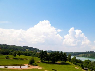 Polonya, Kashubia 'daki Wiezyca bölgesinin kırsal arazisi. Arka planda otlaklar, çayırlar ve Ostrzyckie gölü.