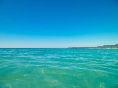 Mavi, şeffaf Tyrhenian deniz suyu mavi gökyüzü arka planında. Tatiller ve doğa konsepti. Boşluğu kopyala.