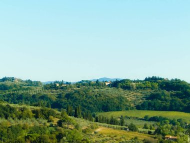 Tepeler, tarlalar ve çayırlar - tipik Toskana manzarası, İtalya. Seyahat, doğa ve tarım kavramı. Güneşli bir sonbahar günü, İtalya 'da tatiller. Boşluğu kopyala.
