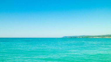 Sahil ve şeffaf, Tiren Denizi 'nin turkuaz suyu. Seyahat ve doğa kavramı. Güneşli bir yaz günü. Boşluğu kopyala.