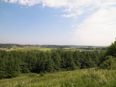 Tepeler, tarlalar ve çayırlar. Wiezyca 'nın güzel manzarası, Kashubia Bölgesi, Kuzey Polonya. Boşluğu mavi gökyüzünde kopyala.