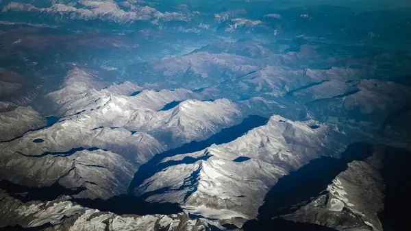 Alpler, uçağın penceresinden dağların manzarası. Toprak bükme ve doğa kavramı.