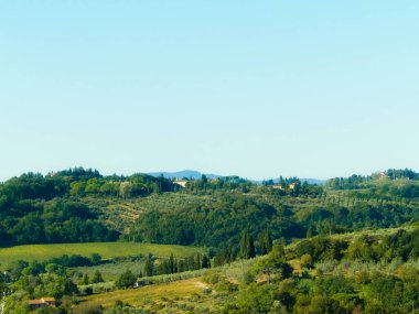 Tepeler, tarlalar ve çayırlar - tipik Toskana manzarası, İtalya. Seyahat, doğa ve tarım kavramı. Güneşli bir sonbahar günü, İtalya 'da tatiller. Boşluğu kopyala.