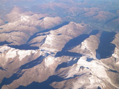 Alpler, uçağın penceresinden dağların manzarası. Toprak bükme ve doğa kavramı.