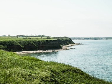 Karadeniz kıyısındaki kayalıklarda yeşil çimenler. Romanya 'nın Dobrogea bölgesinin Vama Veche kentindeki kayalıkların manzarası ve plajlar. Doğa ve seyahat kavramı.