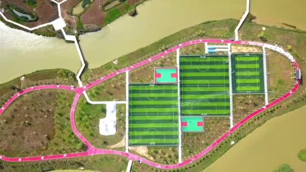 湖の真ん中の島の新しいサッカー場の空中写真 — ストック動画
