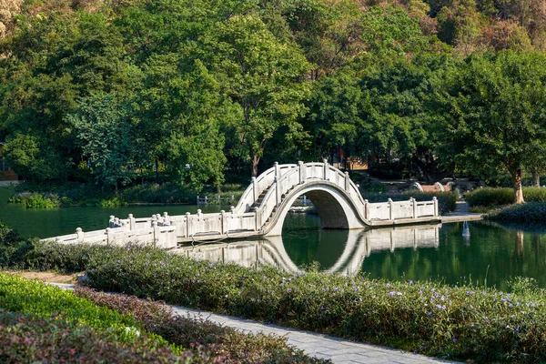 Chinese traditional stone bridge over lake in park