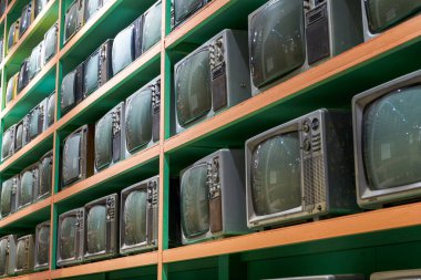 Duvarın her tarafında eski CRT televizyonları var.