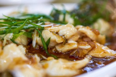 Lezzetli bir Çin yemeği, buğulanmış deniz levreği filetosu.