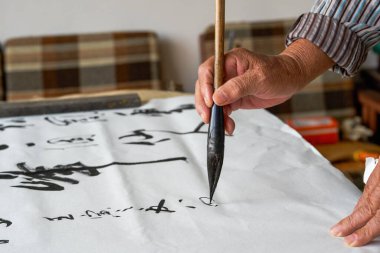 Eski bir Çinli hattat yazı karakterleri yazıyor, kaligrafi çalışmaları yaratıyor.