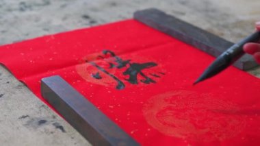 An old calligrapher is writing the Spring Festival couplets posted during the Chinese New Year