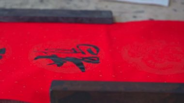 An old calligrapher is writing the Spring Festival couplets posted during the Chinese New Year
