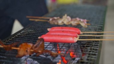 A group of people are grilling in front of the charcoal stove, grilling various ingredients