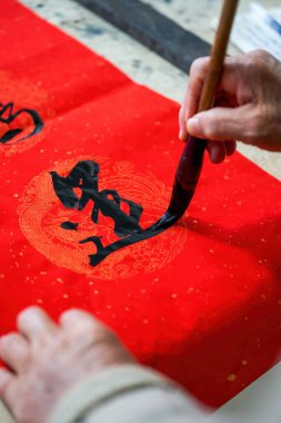 Eski bir Çinli hattat Çin Bahar Festivali çifti yazıyor.