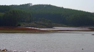 Reservoir, green hills, trees, lake scenery outdoors on a sunny day