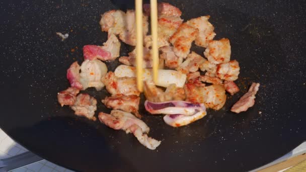 Person Frying Pork Belly Cast Iron Pan Outdoors — 图库视频影像