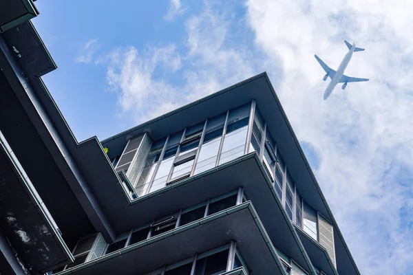 飛行機は市内の近代的な建物の上を飛ぶ — ストック写真