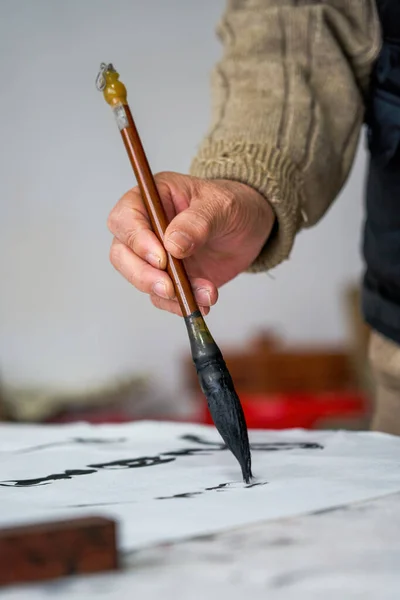 stock image An old Chinese calligrapher is creating and writing calligraphy works.Translation: carry on the past and open up the future.