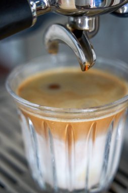 Kahveci espresso makinesiyle kahve yapıyor.