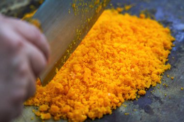 Bir şef mutfakta tuzlanmış yumurta sarısı doğruyor.