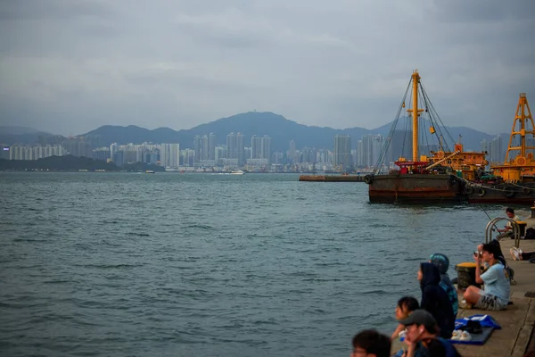 İnsanlar Hong Kong sokaklarında gün batımını seyrediyor.