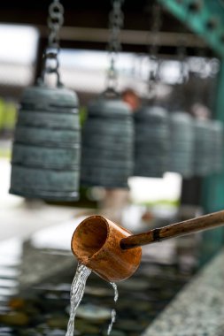 Hong Kong 'daki Tsz Shan Manastırı' ndaki su birikintisini ahşap su kaşığı ve çanlarıyla kapatın.