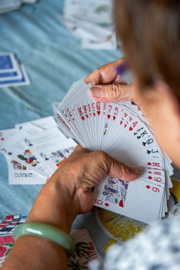 Bir grup yaşlı insan oturup poker oynuyor.