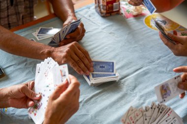 Bir grup yaşlı insan oturup poker oynuyor.