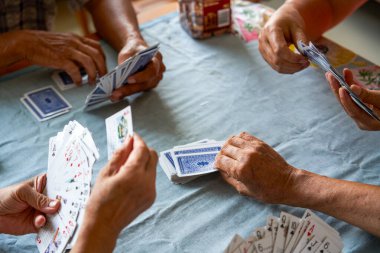 Bir grup yaşlı insan oturup poker oynuyor.