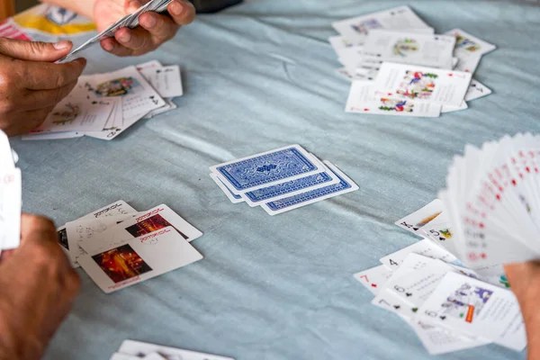 Bir grup yaşlı insan oturup poker oynuyor.