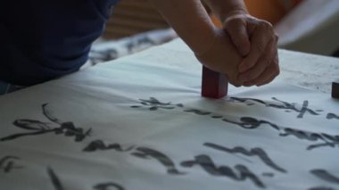 Bir kaligraf çalışmalarını damgalar.