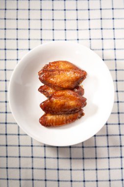 Bir tabak altın ve cazip ballı ızgara tavuk kanadı.