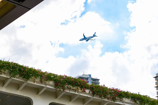 Civil aviation aircraft flying over modern buildings in the city