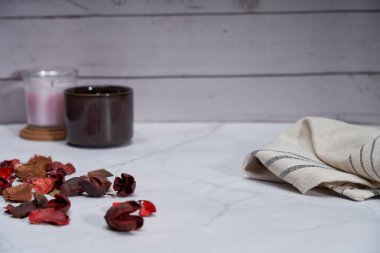 Konforlu ev kokulu mum ve kurutulmuş çiçek yaprakları peçete arka planı